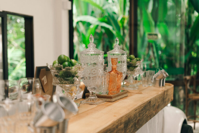 Mesa de bar decorada com jarras de cristal para celebração no Sítio Geranium