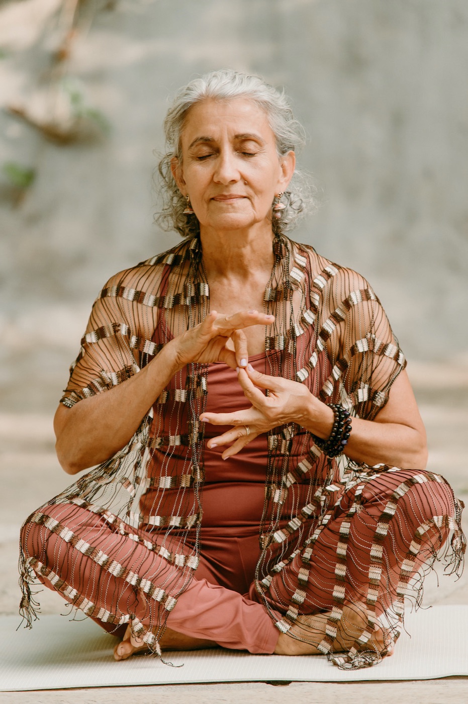 Instrutora em prática de meditação com as mãos em mudra no Sítio Geranium