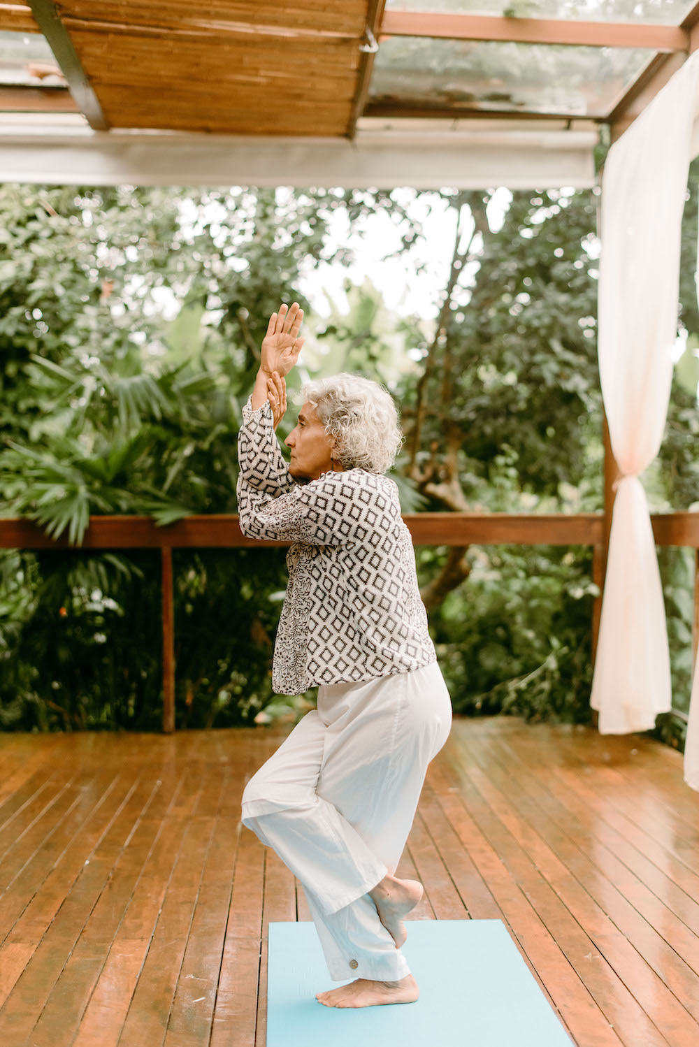 Prática individual de yoga em deck de madeira
